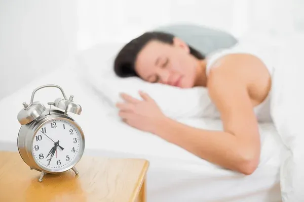 Alarm clock beside a work schedule printout